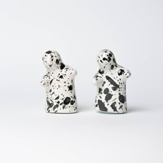 Black and white hugging salt and pepper shakers with splatter pattern