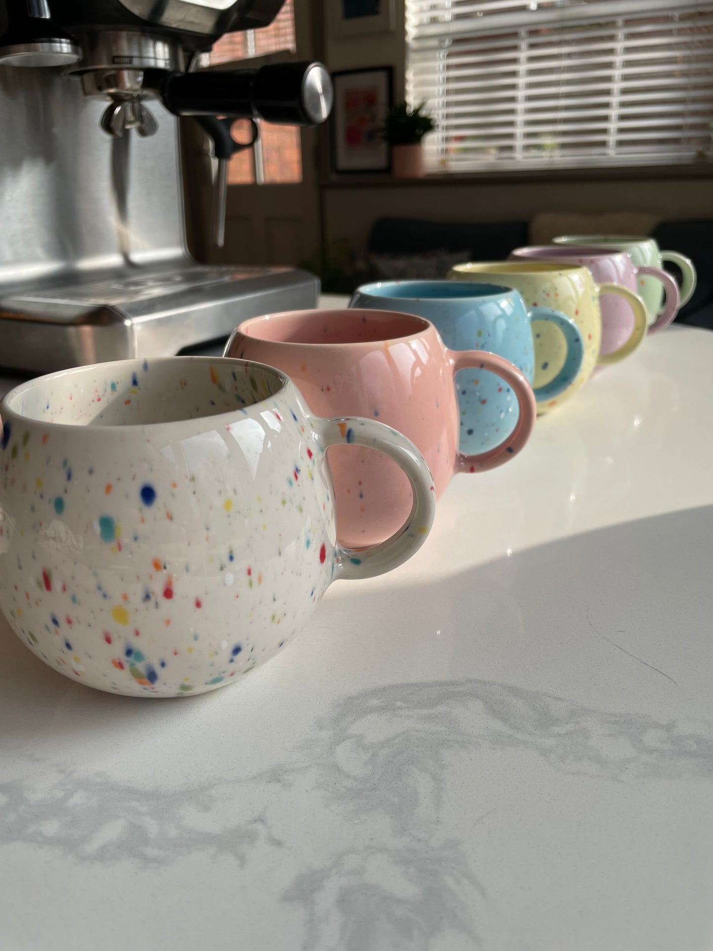 Rainbow of 6 colours of ball mugs with splatter pattern