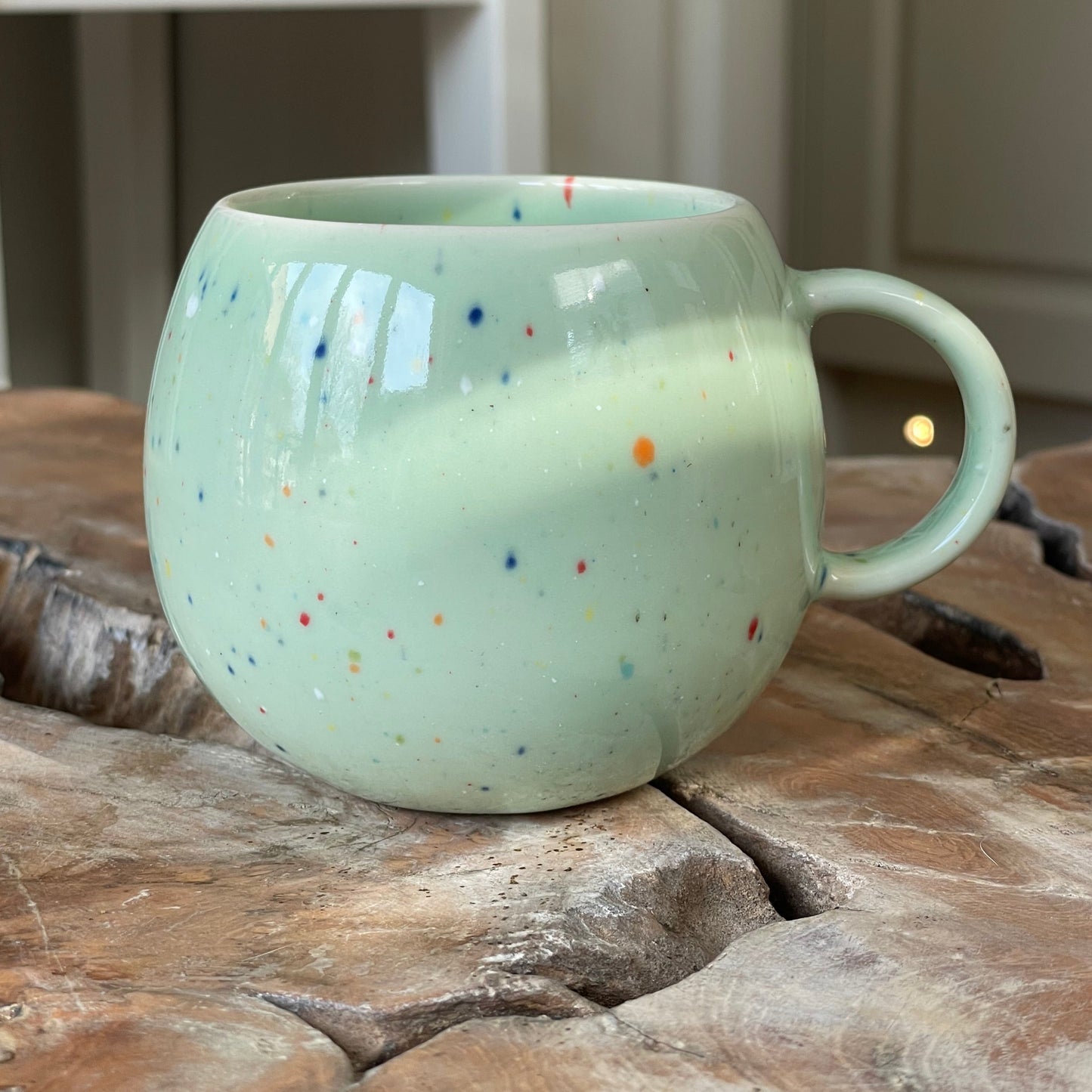 Green ball mug with multi coloured splatter pattern