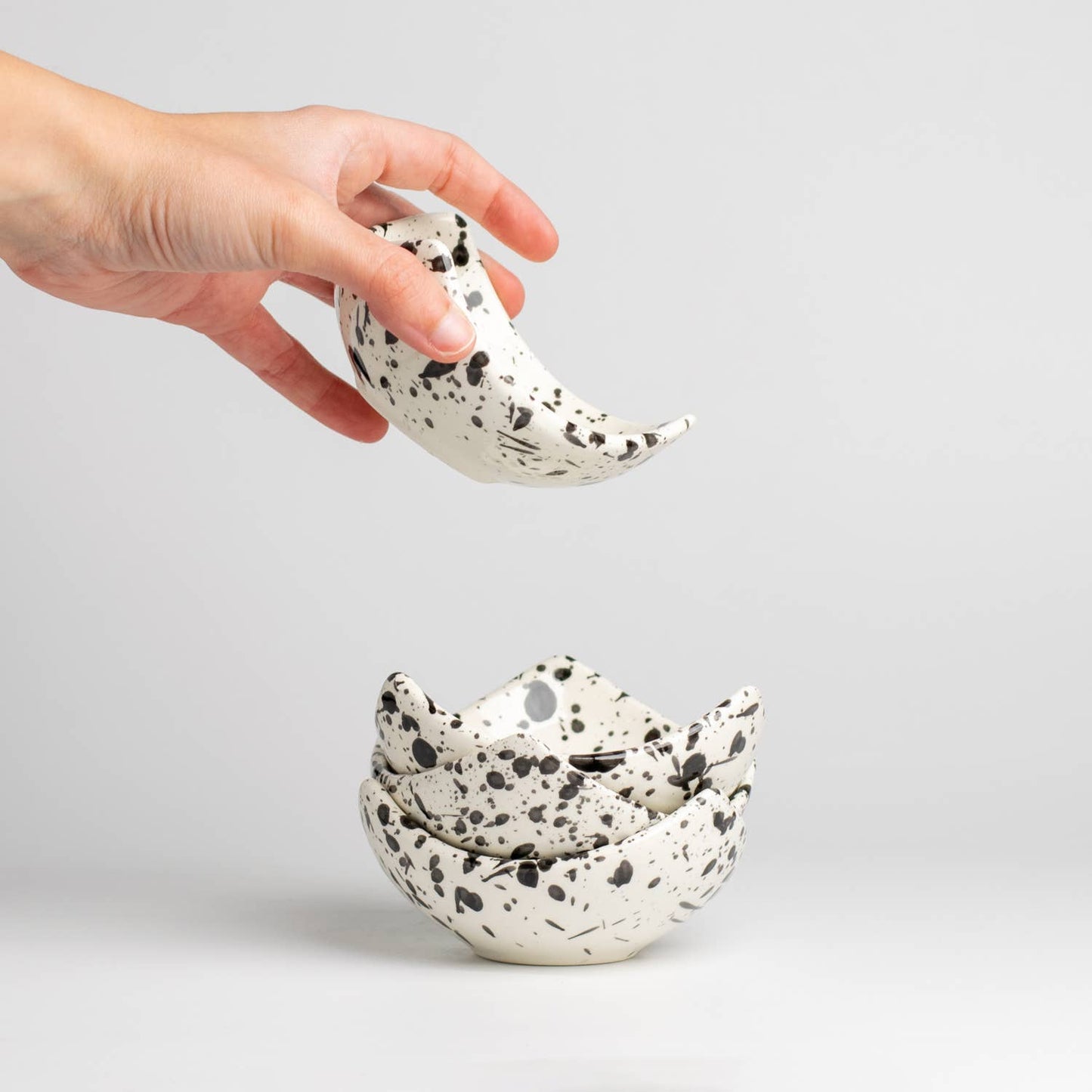 Ceramic triangular bowls with black and white splatter pattern